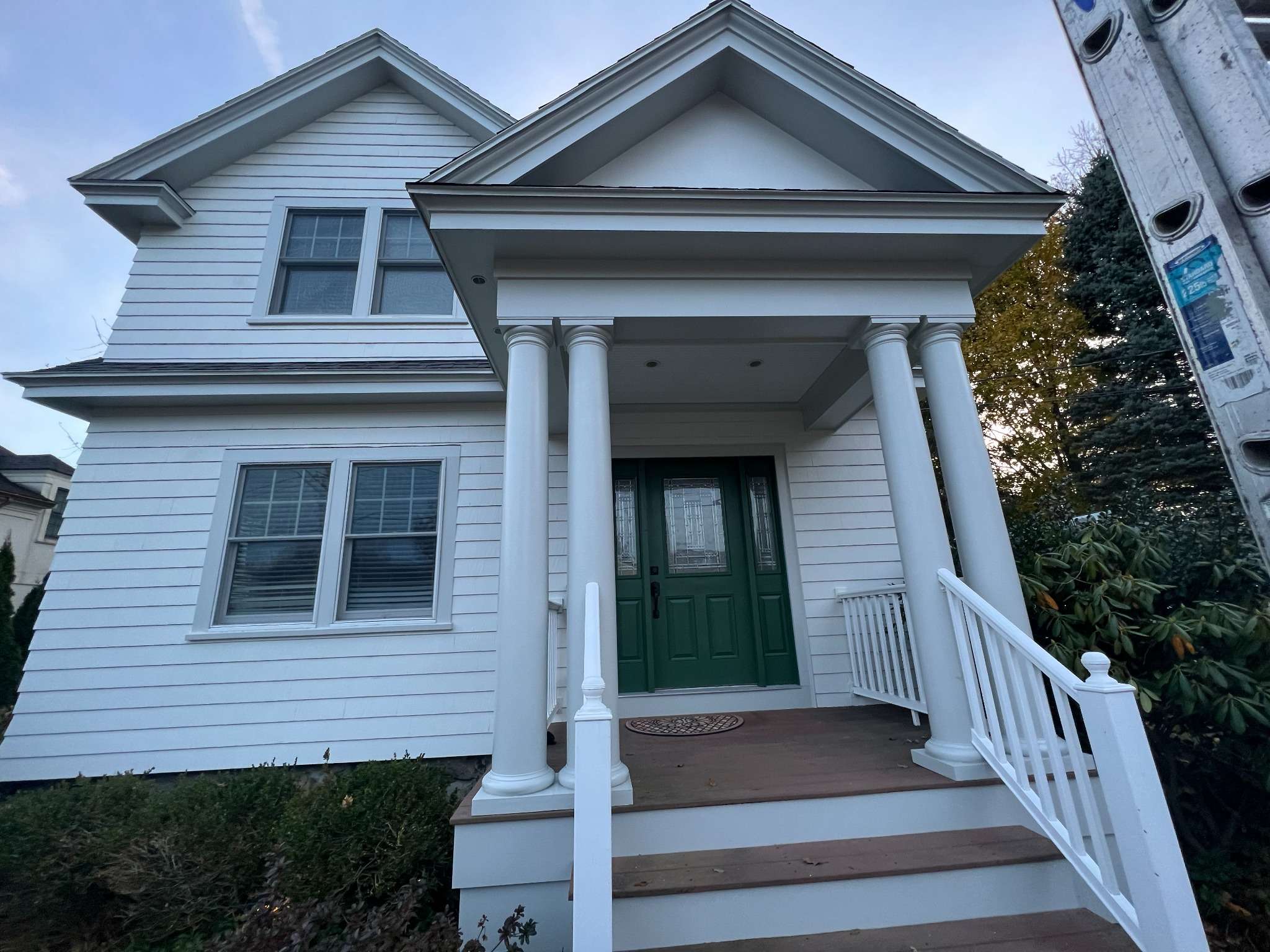 Green front door with white exterior design improving home curb appeal