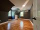 Freshly painted attic bedroom with dark gray walls, sloped ceilings, hardwood floors, and white trim completed by Rodrigo's Painting.