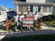 Rodrigo's Painting team standing in front of a home with a company sign promoting residential and commercial painting services.