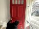 Front door painting in progress with a red finish on a traditional entryway